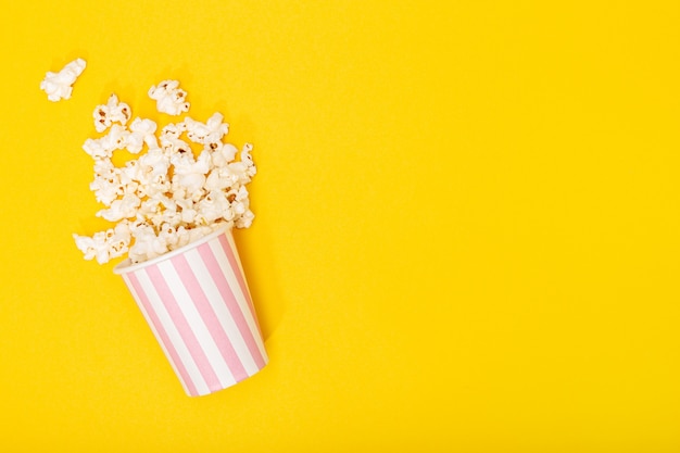 Download Premium Photo Popcorn Bucket On Yellow Background Movie Or Tv Background Top View Copy Space PSD Mockup Templates