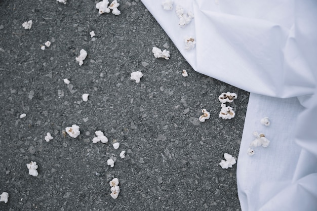 Popcorn on ground near white sheet Free Photo