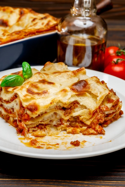 Premium Photo | Portion of lasagna closeup on wooden backgound