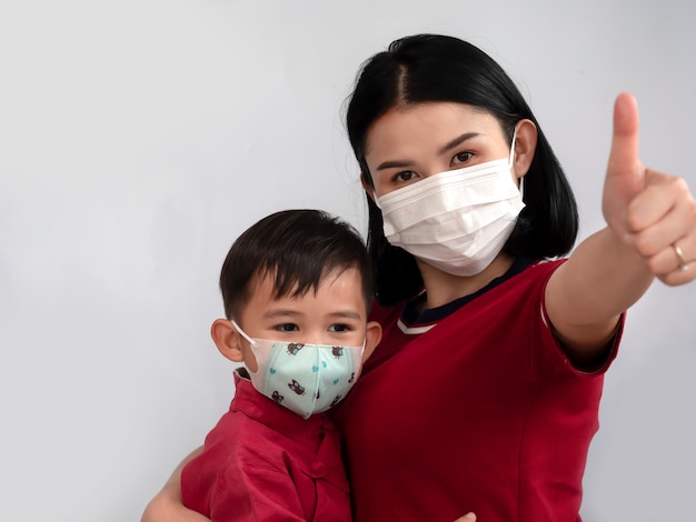 Premium Photo | Portrait of asian family mom and son showing thumb up and wear  mask