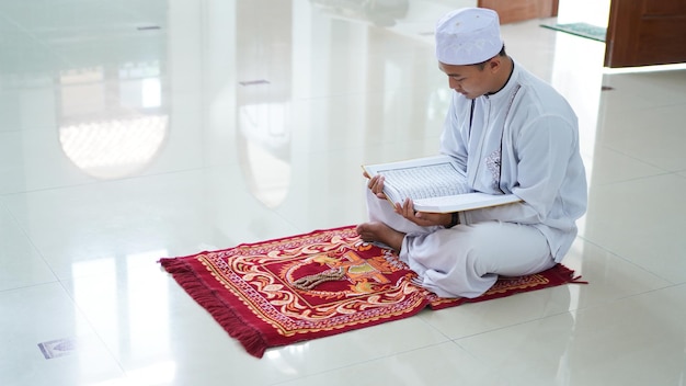 Premium Photo | A portrait of an asian muslim man holding quran