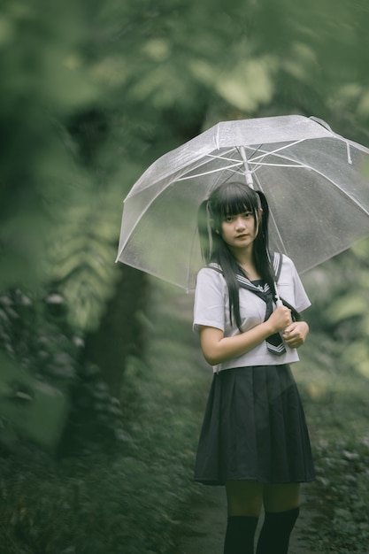 Premium Photo Portrait Of Asian School Girl Walking With Umbrella At Nature Walkway On Raining