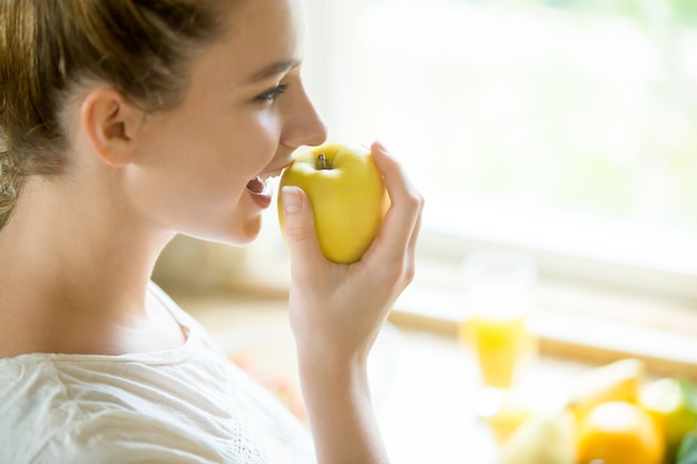 Portrait of an attractive woman eating an apple Free Photo