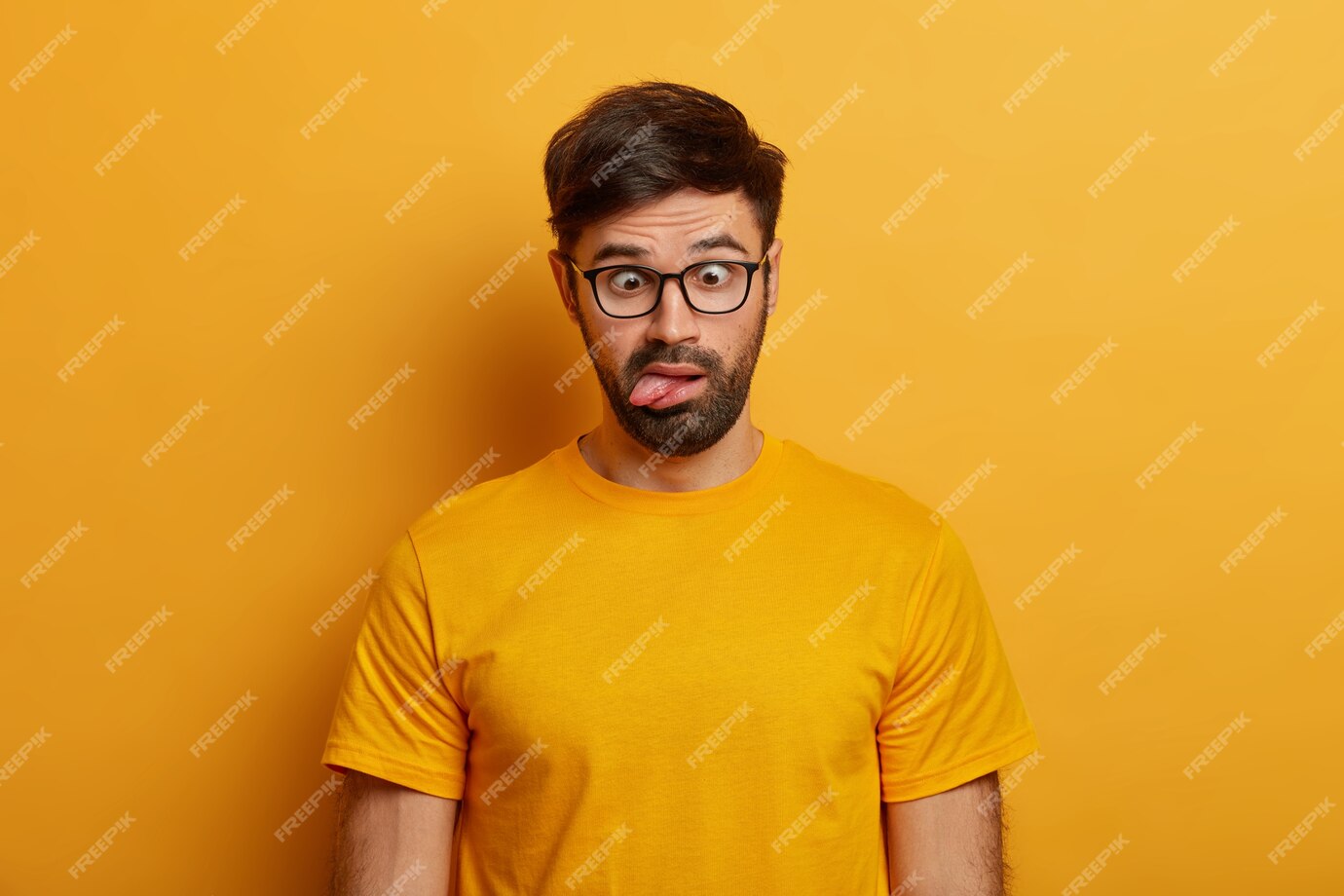 Free Photo Portrait Of Bearded Guy Shows Grimace Crosses Eyes And Sticks Out Tongue Plays 5346