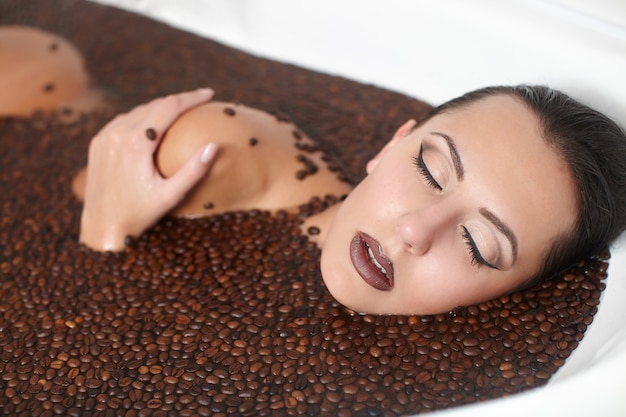 Portrait of beautiful fashion woman in jacuzzi with coffee. body care. bright makeup Free Photo