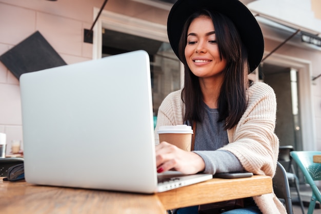 Free Photo | Portrait of a beautiful smiling woman typing on laptop