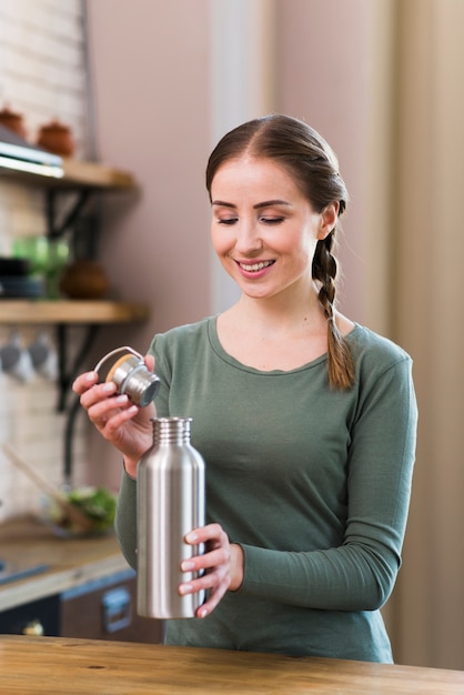 Portrait of beautiful woman holding thermos  Free Photo