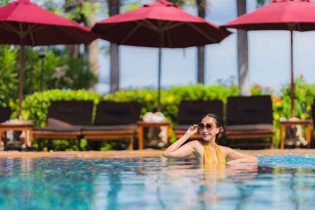 Portrait beautiful young asian woman leisure relax smile and happy around swimming pool in hotel resort Free Photo