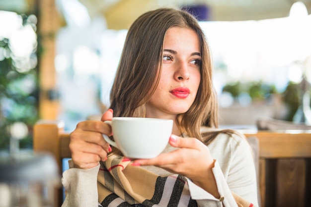 A woman holding a white ceramic cup. | Photo: Freepik