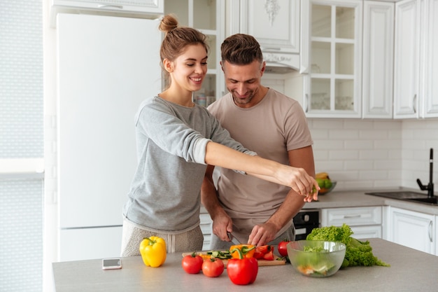 Portrait of a cheerful loving couple cooking salad together Free Photo