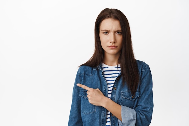 Free Photo | Portrait of concerned young woman frowning, pointing left ...