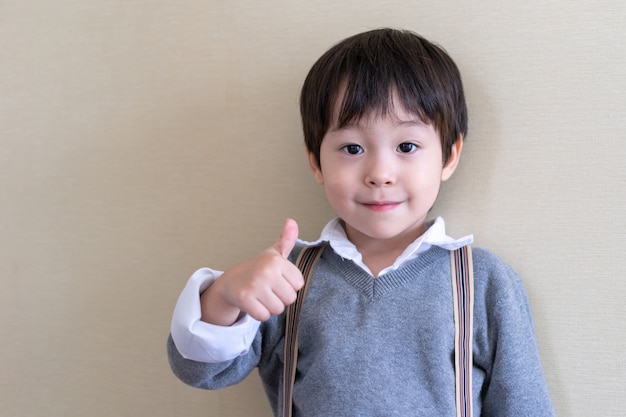 Portrait cute boy standing and thump up Free Photo