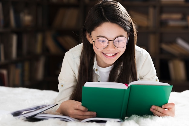 Portrait of cute little girl reading a book Free Photo