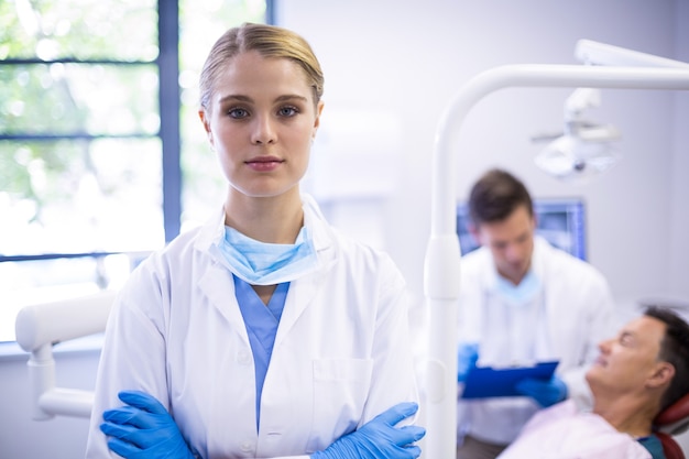 Premium Photo | Portrait of dentist standing with arms crossed