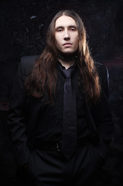 Premium Photo Portrait Of A Fashionable Male Model With Long Hair Over Dark Background Studio Shot