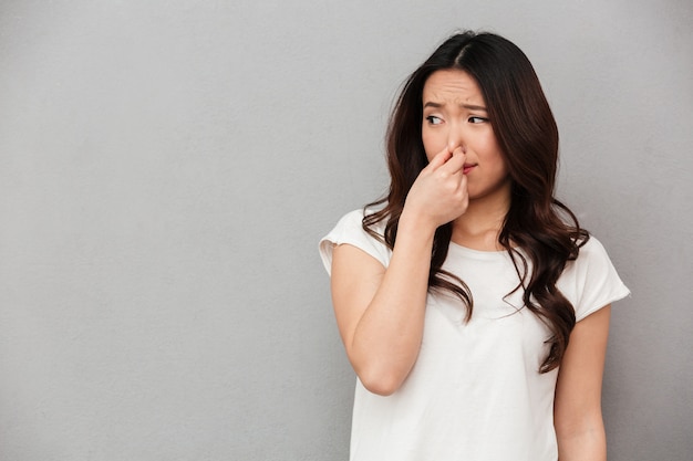 Premium Photo | Portrait of frustrated woman 20s pinching nose with ...