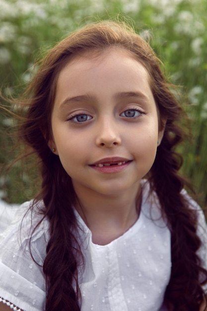 Premium Photo | Portrait girl child in a white dress stands on a ...