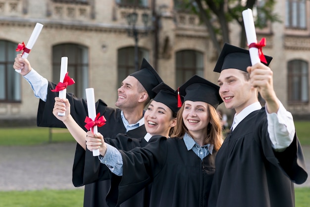 Portrait of group of students celebrating their graduation Free Photo