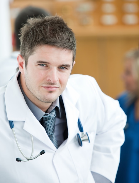 Premium Photo | Portrait of a handsome surgeon with his team behind him