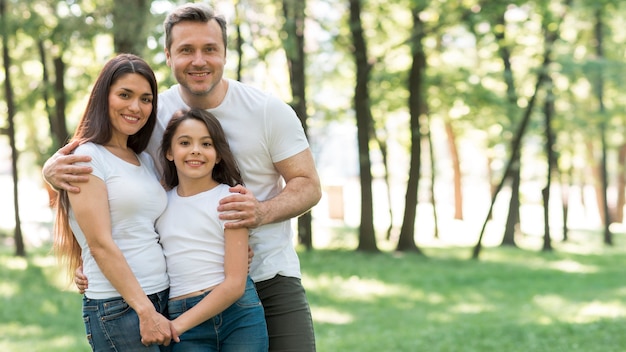 Portrait of happy family in white t-shirt standing together at park Free Photo