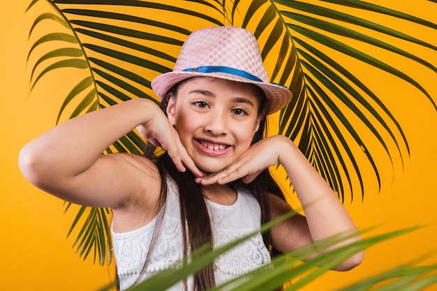 Premium Photo | Portrait of happy girl with hat and palm leaves on ...