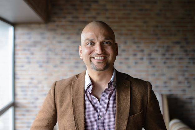 Portrait of happy handsome indian business man, smiling, confident and friendly indoors. Premium Photo