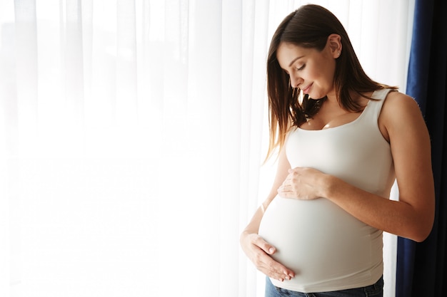 pregnant woman cradling her bump in black and white