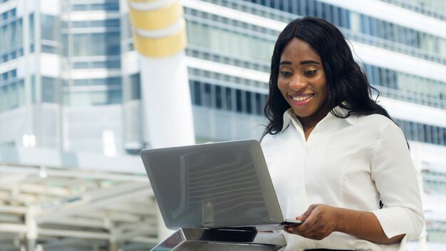 Portrait of happy and surprising business african woman uses ...