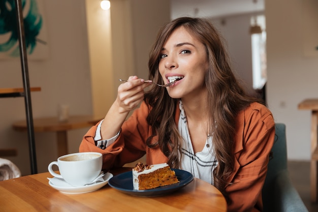 Free Photo Portrait Of A Happy Woman Eating A Piece Of Cake