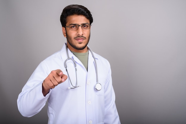 Premium Photo | Portrait of indian man doctor against gray background