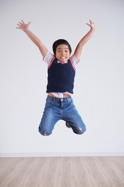 Portrait of little boy jumping happily high in the air Photo | Free ...