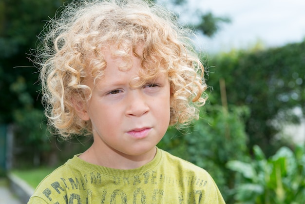Portrait Of Little Boy With Blond And Curly Hair Premium Photo