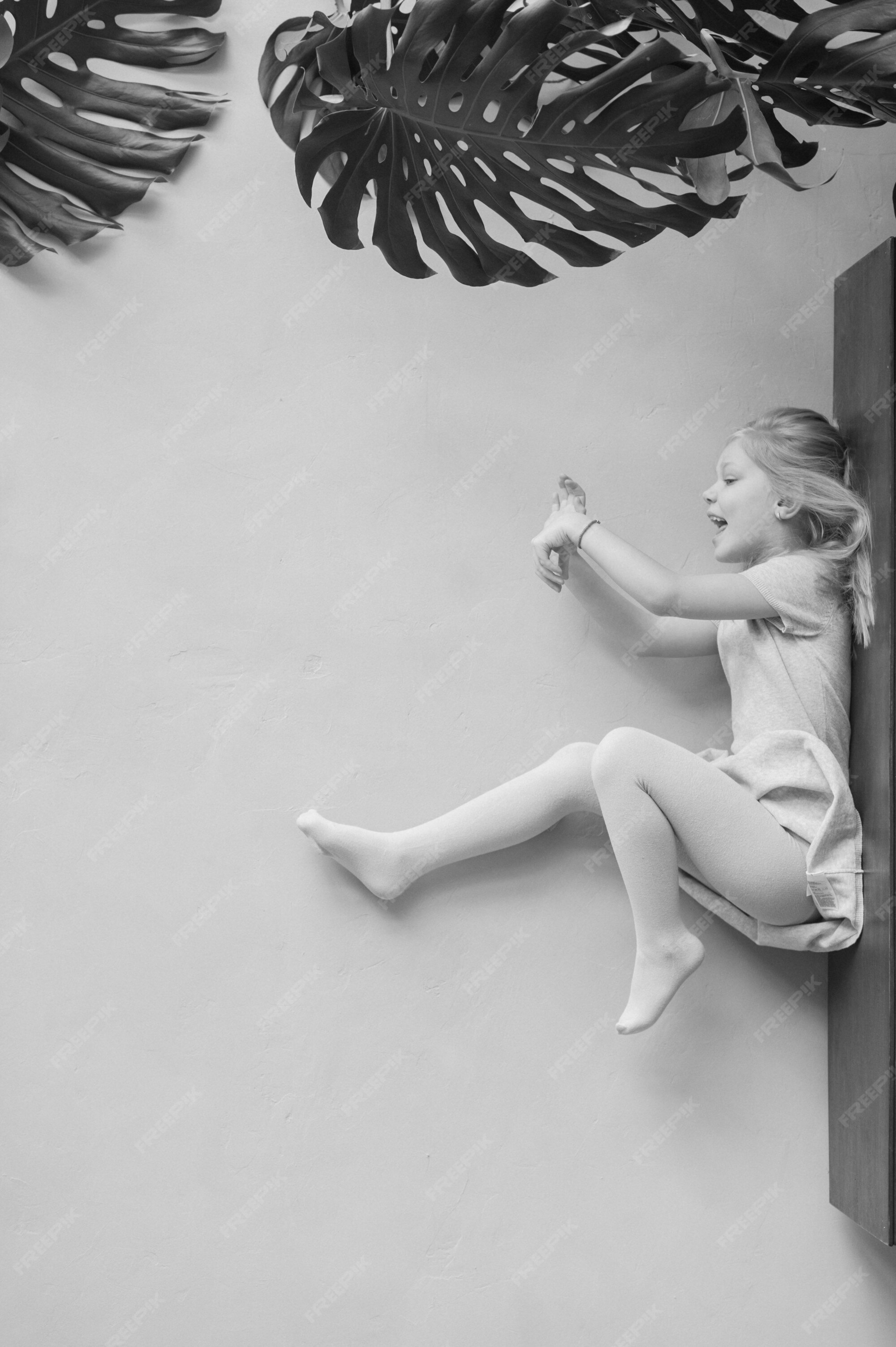 premium-photo-portrait-of-little-girl-lying-on-table-with-legs-and