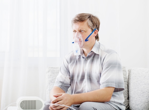 Premium Photo | Portrait of man inhaling through inhaler mask