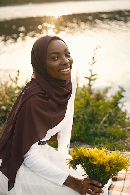 Premium Photo Portrait Of A Muslim Woman Sits On The Plaid Picnic Blanket Near The River 1403