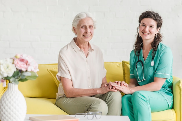 Portrait Of Nurse Sitting With Senior Female Patient On Sofa Free Photo 1245