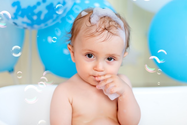 風船とシャボン玉 幸せな子供時代 子供の誕生日と一緒にお風呂で入浴する男の子の肖像画 プレミアム写真