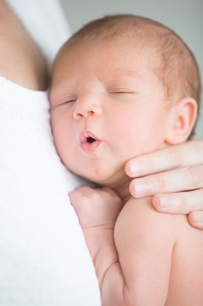 かわいい新生児の肖像画は 母親の乳房で保持する 無料の写真