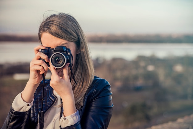 Portrait of a photographer covering her face with the camera. Ph Free Photo