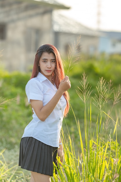 アジアやタイの学生大学制服美少女の肖像画は リラックスして笑顔 プレミアム写真