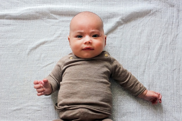 かわいい赤ちゃんのクローズ アップの肖像画 かわいい赤ちゃんがカメラに見えます 茶色の目と長いまつげのハゲの赤ちゃん プレミアム写真