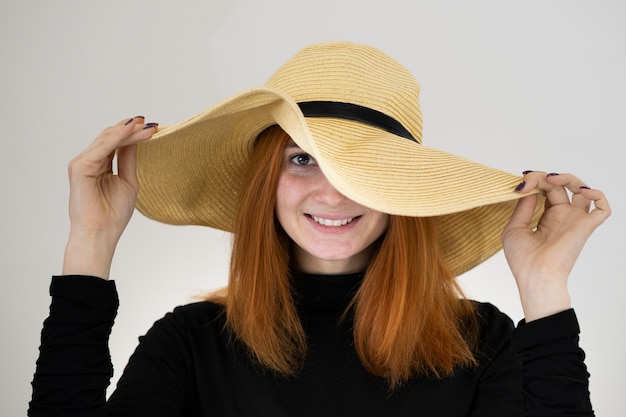 バッグ黄色い麦わら帽子で面白い赤毛の女性の肖像画 プレミアム写真