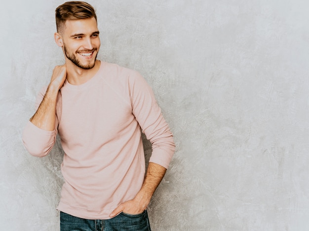 カジュアルな夏のピンクの服を着てハンサムな笑みを浮かべて若い男モデルの肖像画 ファッションスタイリッシュな男のポーズ 無料の写真