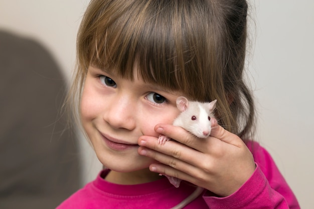 白いペットのハムスターと幸せな笑顔かわいい子少女の肖像画 プレミアム写真