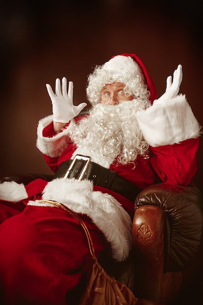 サンタクロースの衣装 豪華な白ひげ サンタさんの帽子 赤いスタジオの背景に赤い衣装の男の肖像 無料の写真