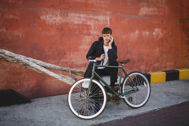 自転車で立っている茶色の髪の若い男の肖像画 プレミアム写真