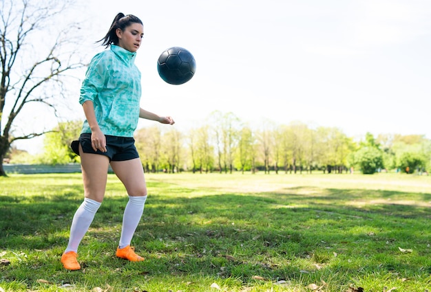 サッカーのスキルを練習し サッカーボールでトリックを行う若い女性の肖像画 ボールをジャグリングするサッカー選手 プレミアム写真