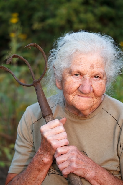 Premium Photo Portrait Of An Old Woman With Gray Hair Holding A Rusty Pitchfork
