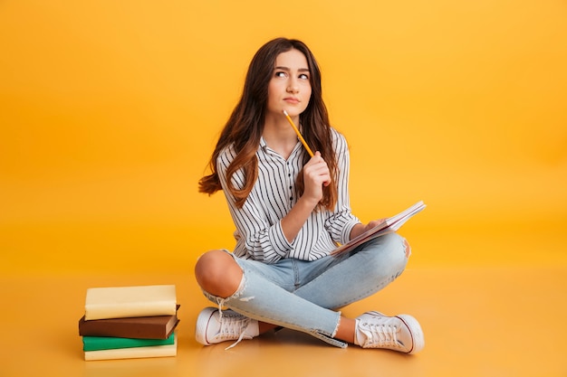 Portrait of a pensive young girl making notes Free Photo