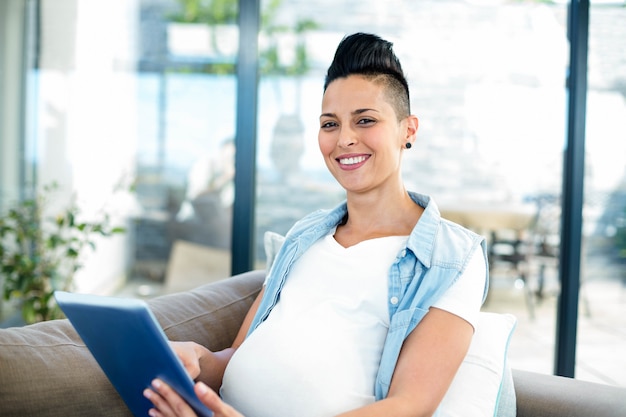 Portrait Of Pregnant Woman Using Digital Tablet While Relaxing On